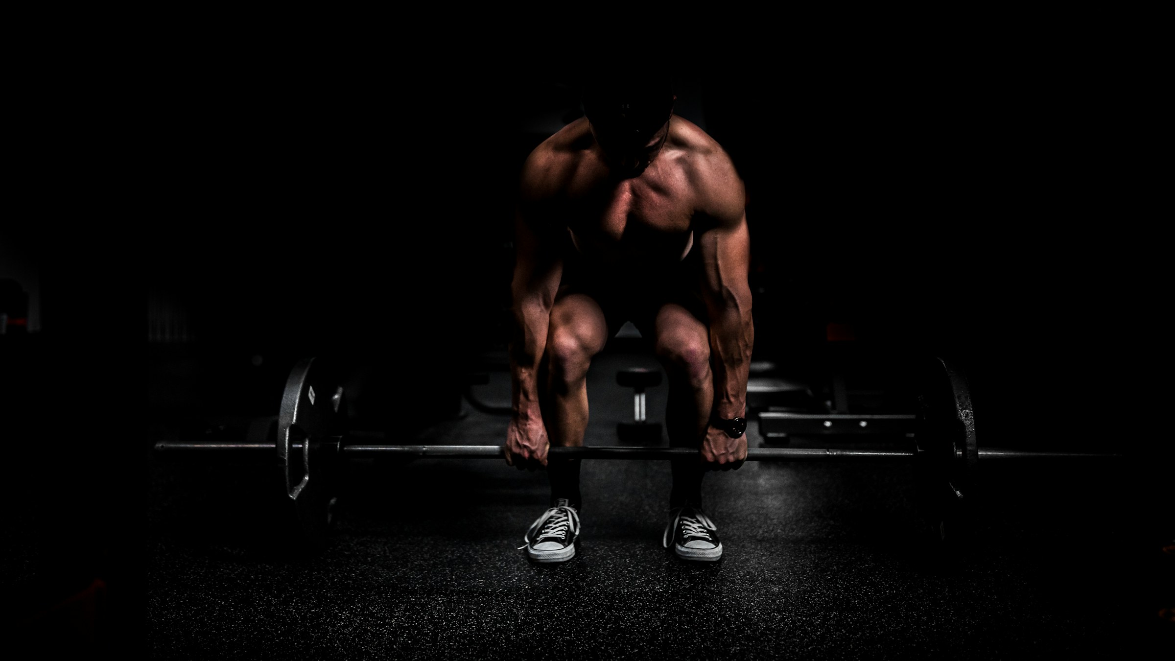 Athlete training with a barbell in low light